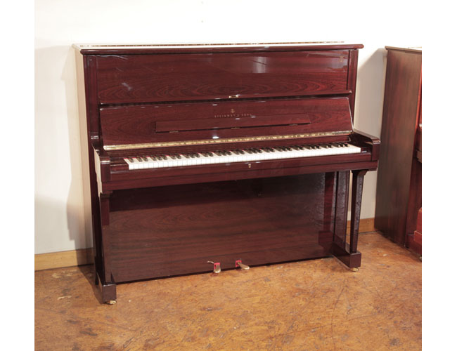 As new,  2009, Steinway model V upright piano with a mahogany gloss case. Piano has an eighty-eight note keyboard and two pedals . 