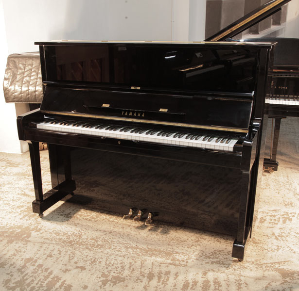 A 1977, Yamaha U1 upright piano in black gloss with brass fittings 