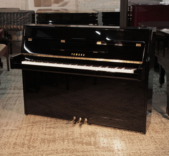 Pre-owned, 2022, Yamaha b2e PE upright piano with a gloss black case and brass fittings. Condition as new. Piano has an eighty-eight note keyboard and three pedals.