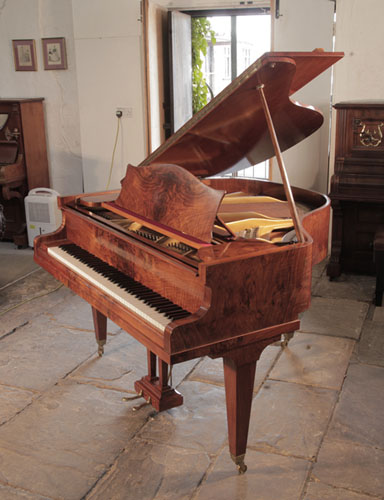 A 1936, Bechstein baby grand piano for sale with a figured, walnut case and square tapered legs.